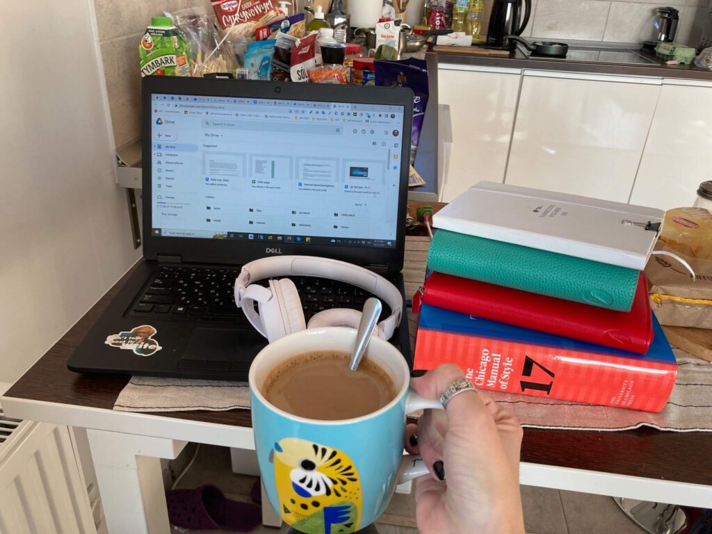 my work station as a writer - laptop, Chicago Manual of Style, Filofax planners, and coffee